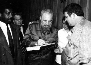 Fidel Castro signs a photo for Patrick Manteiga. The photo he's signing is a shot of Manteiga’s grandfather in Tampa giving Castro money for the revolution. (Photo courtesy of Patrick Manteiga.)